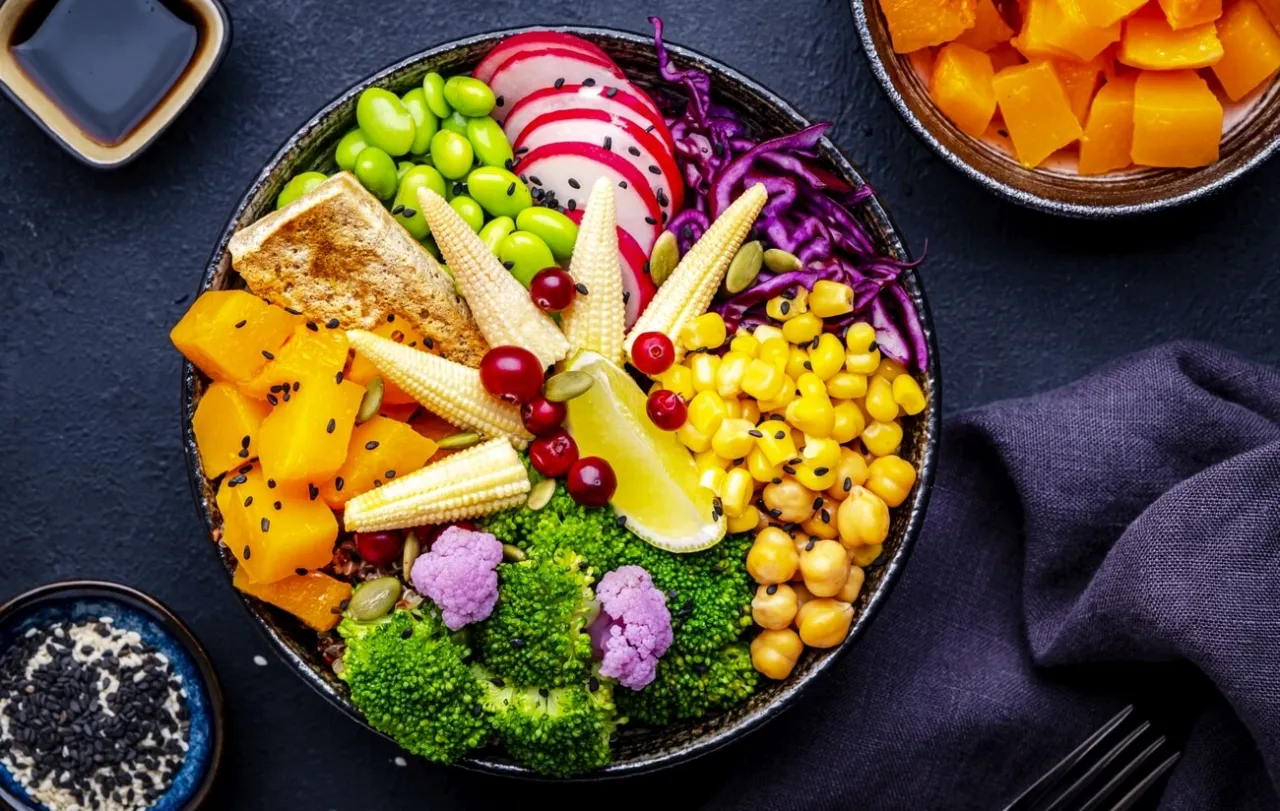 Kolorowa miska pełna warzyw: dynia, kukurydza, brokuły, ciecierzyca, edamame, mini kukurydza, rzodkiewka, czerwona kapusta. Idealna inspiracja, jak zacząć dietę wegańską.