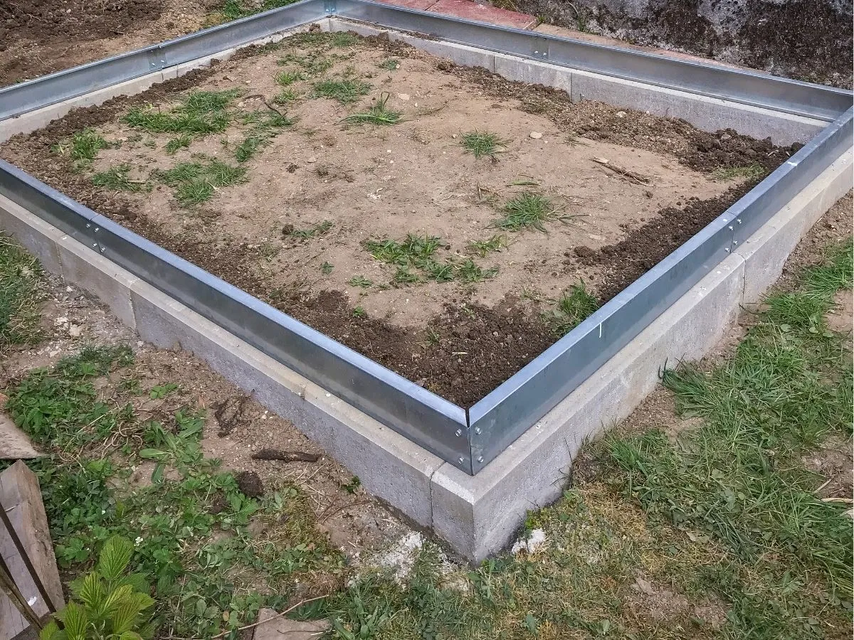 Fundament pod szklarnię z bloczk&oacute;w betonowych i metalowych profili. Gotowy do dalszych prac budowlanych.