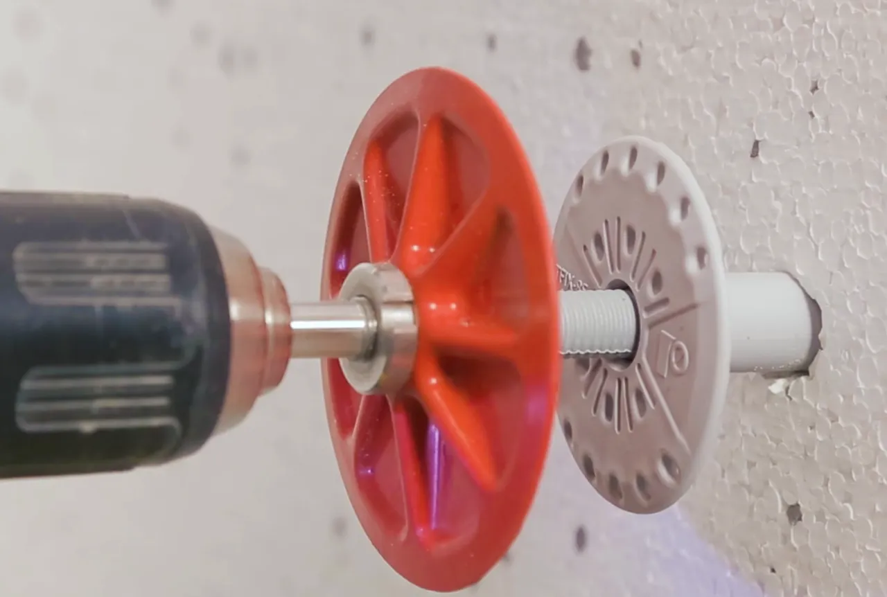 Wkrętarka montuje kołek do styropianu, co jest kluczowe, jak zamontować lampę na elewacji.