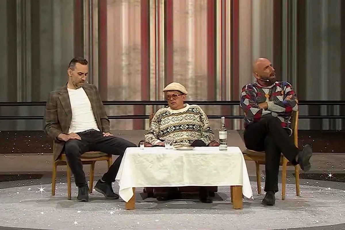 Trzech mężczyzn siedzi przy stole. Jeden w swetrze z wzorami, drugi w marynarce, trzeci w kolorowym swetrze. Kabaret Neo-N&oacute;wka najnowsze pis.