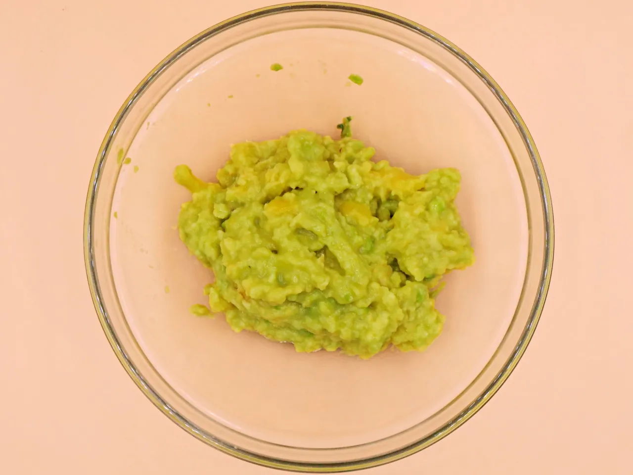 Zielone, rozgniecione awokado w szklanej misce. Czy guacamole jest zdrowe? Tak, to pyszna i zdrowa przekąska!