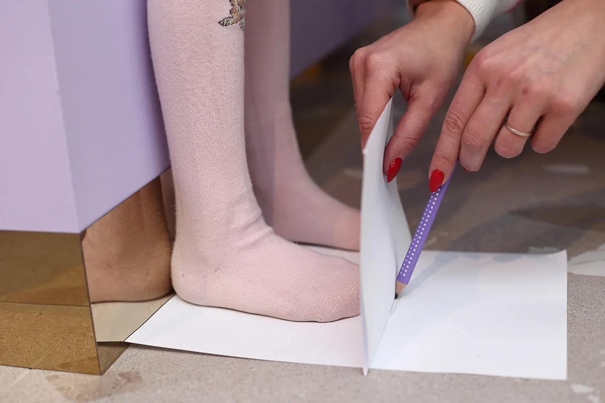 dziecko mierzące stopę na kartce papieru