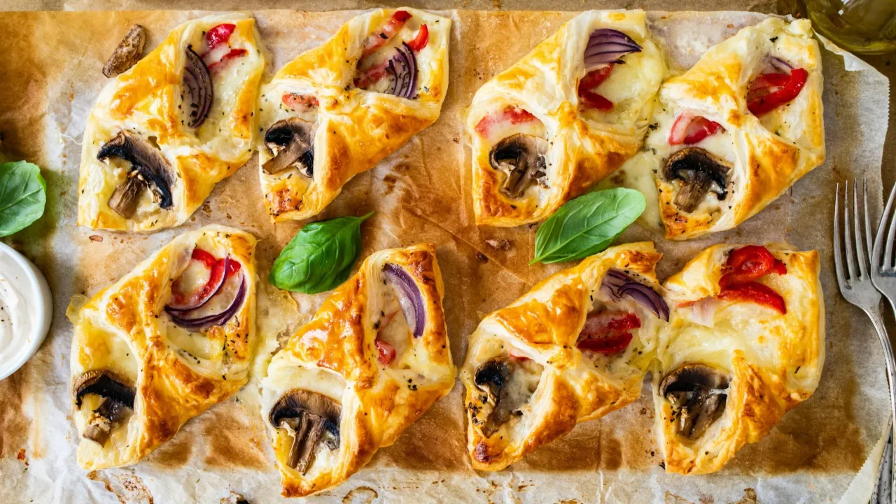Pyszne paczuszki z ciasta francuskiego z pieczarkami, cebulą i papryką. Idealne, gdy zastanawiasz się, jak zawijać ciasto francuskie na szybką przekąskę.