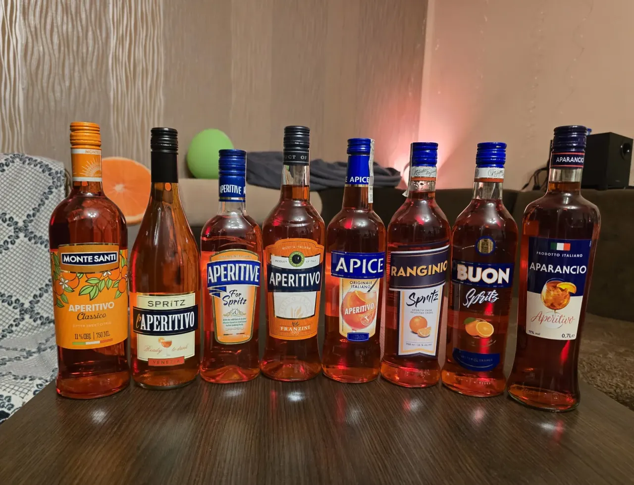 Rząd butelek aperitifów: Monte Santi, L'Aperitivo, Aperitive, Aperitivo, Apice, Ranginio, Buon Spritz, Aparancio. Aperol kontra Campari - wybór należy do Ciebie!