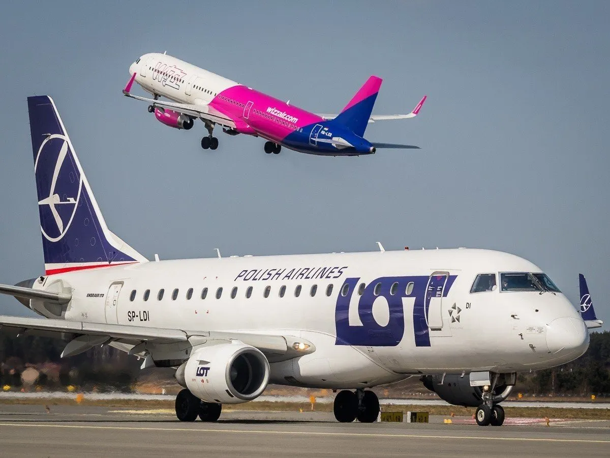 Samolot LOT-u na pasie startowym, w tle wznoszący się Wizz Air. Zastanawiasz się, ile trwa lot z Katowic do Bodrum?