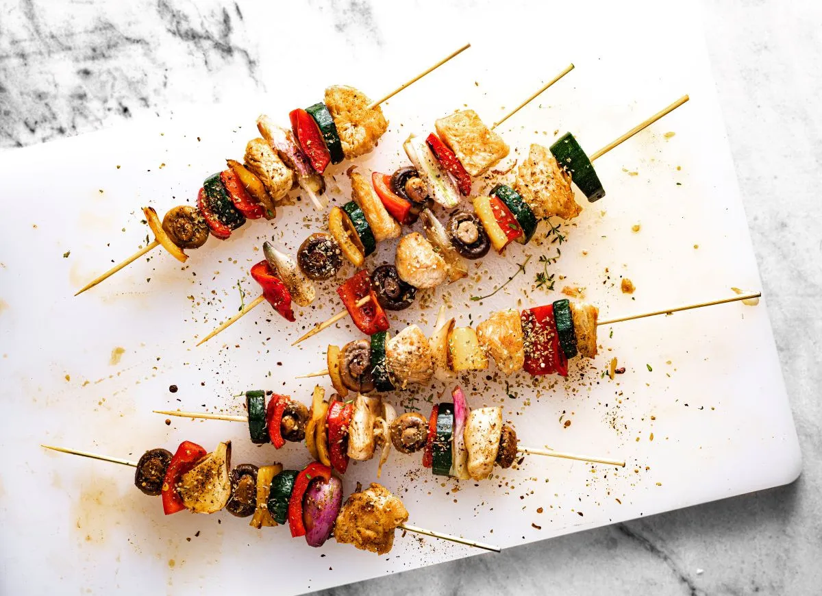 Cztery apetyczne szaszłyki z kurczaka i warzyw, gotowe do pieca.