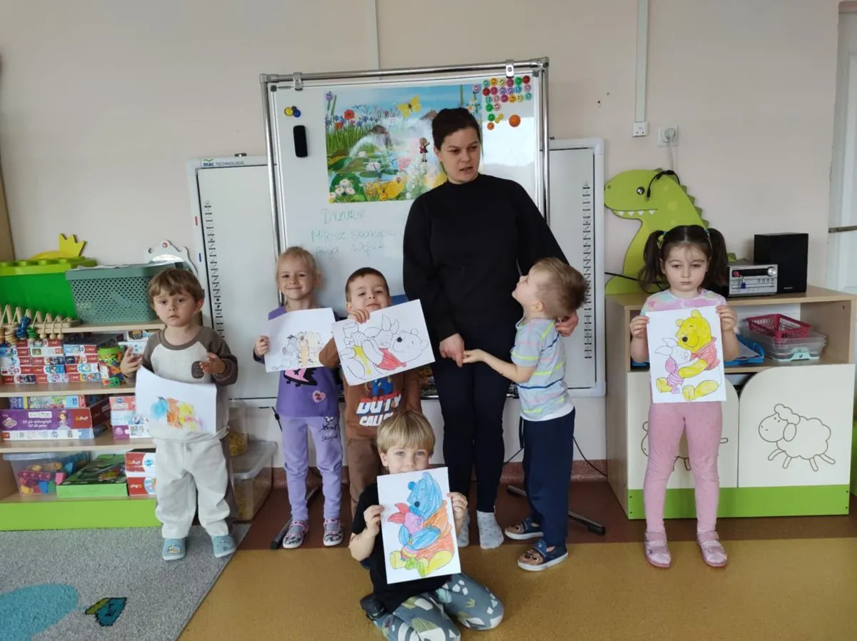 dziecko czytające książkę o przedszkolu z rodzicem