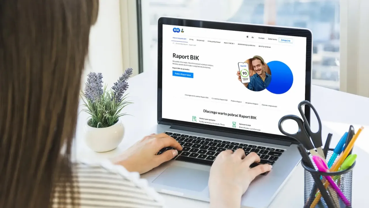 osoba analizująca raport kredytowy na laptopie
