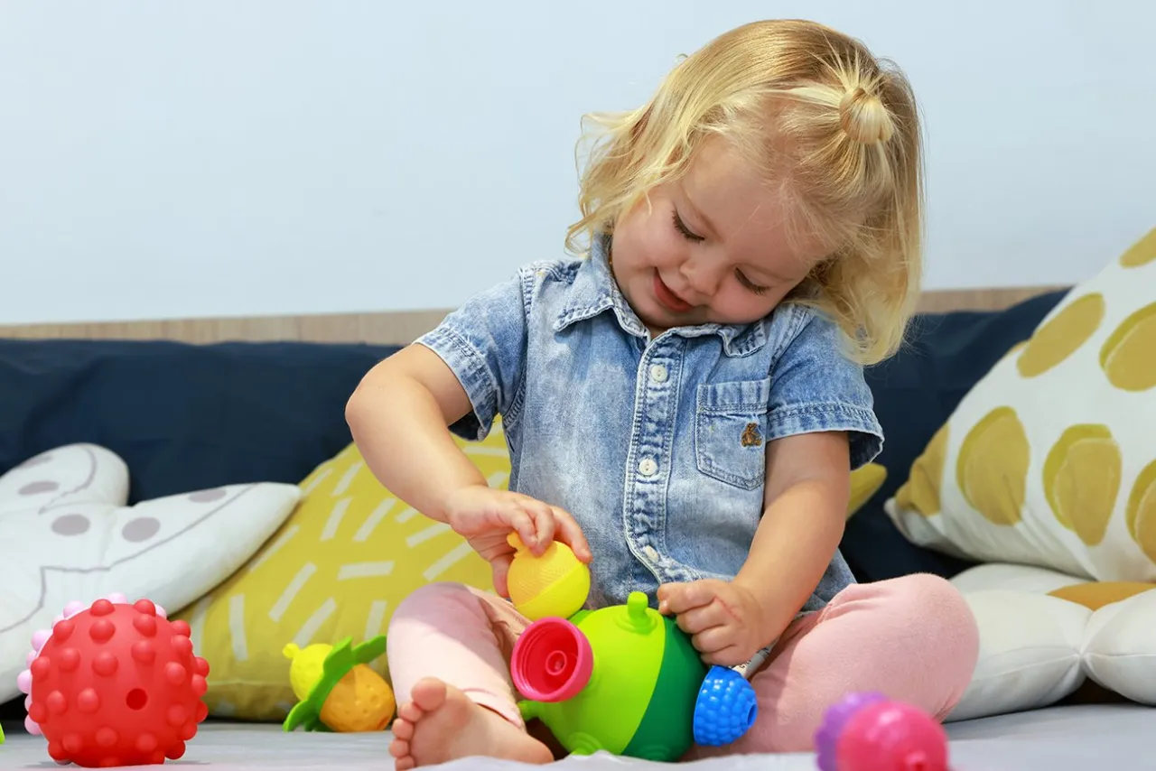 Dziecko bawi się kulko-klockami sensorycznymi, bliskie ujęcie dłoni