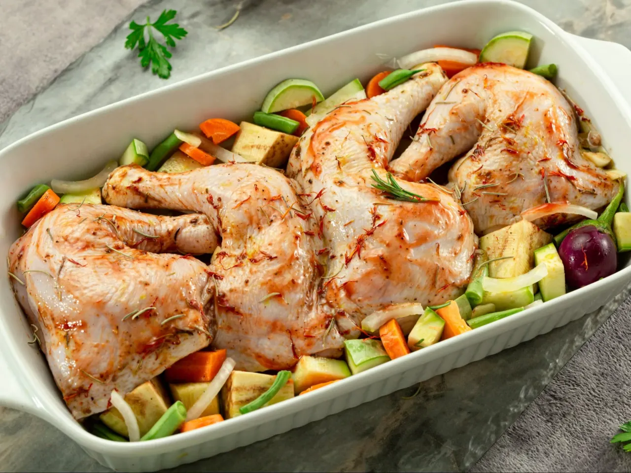 Gotowy do pieczenia kurczak z warzywami w naczyniu. Idealny pomysł na to, co z kurczakiem na obiad.