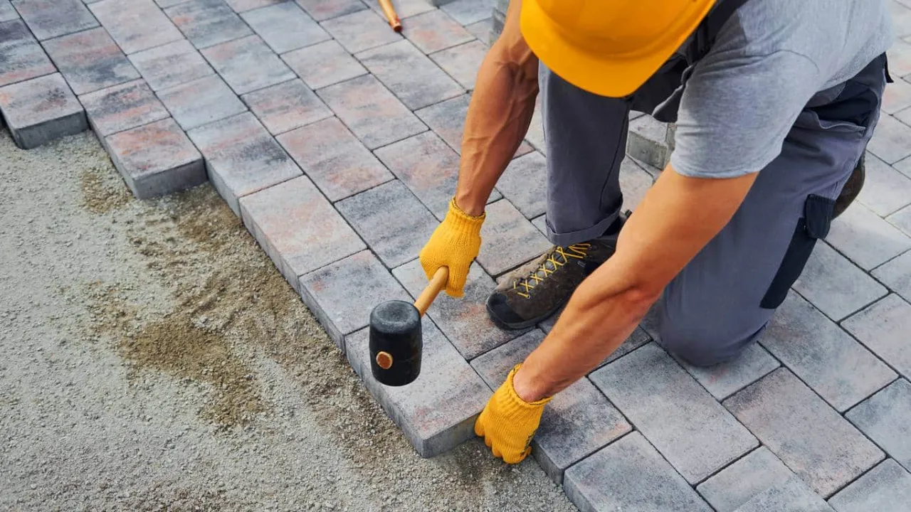 brukarz układa kostkę brukową