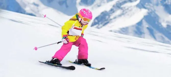 dziewczynka na nartach w kolorowych spodniach, zbliżenie na nogawki