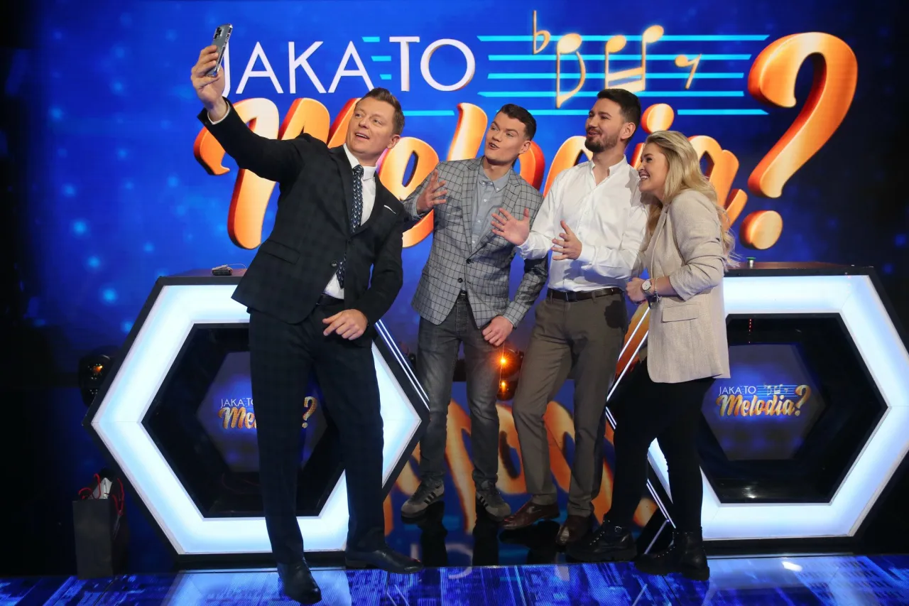 Jaka to melodia obsada robi sobie selfie. Uśmiechnięci uczestnicy pozują na tle scenografii z logiem programu.