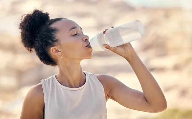 Osoba pijąca wodę po treningu, butelka wody