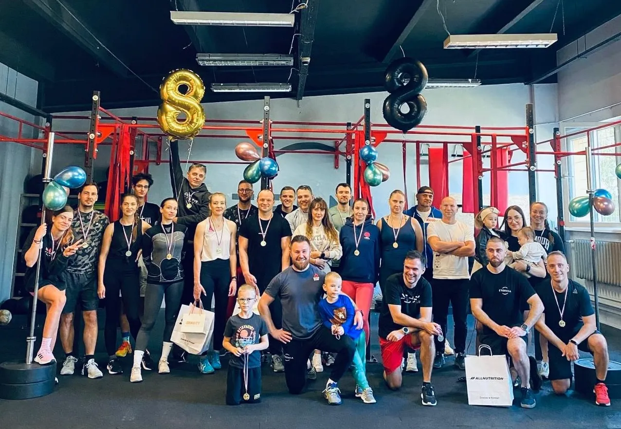 Grupa ludzi w siłowni z balonami w kształcie &oacute;semki. Idealne miejsce, by dowiedzieć się, crossfit od czego zacząć.