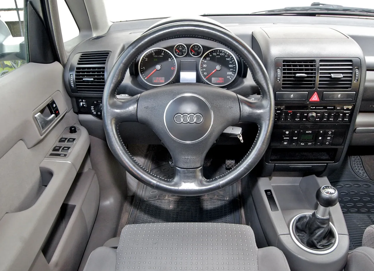 Wnętrze Audi A2 z kierownicą, deską rozdzielczą i dźwignią zmiany biegów. Zastanawiasz się, które audi wybrać?