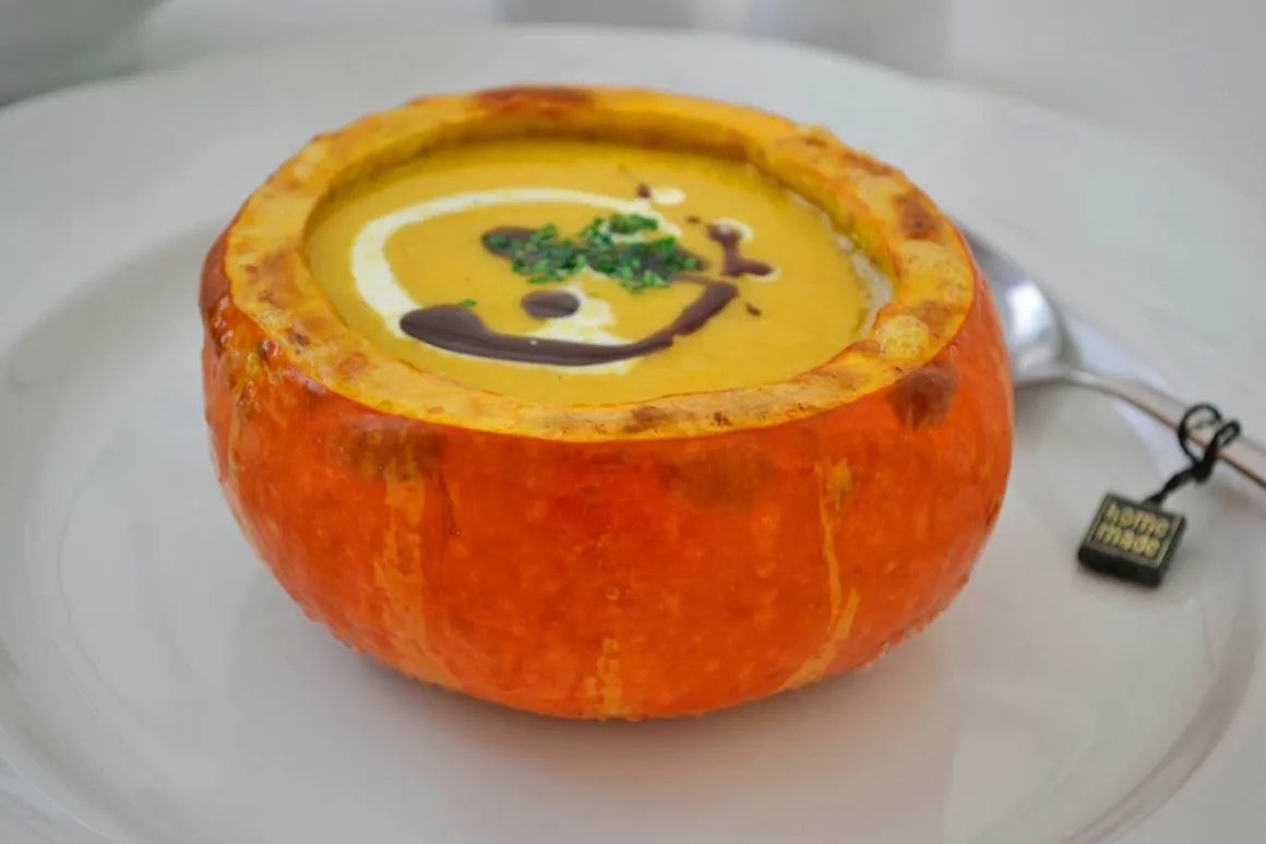 Zutaten für Kürbis-Curry-Suppe auf einem Holztisch angerichtet