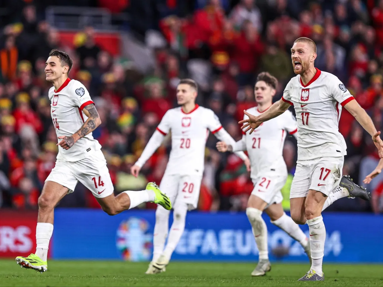 Piłkarze reprezentacji Polski w białych strojach świętują bramkę. Wszyscy biegają po boisku, ciesząc się z sukcesu. To z pewnością ważny mecz, o której godzinie?