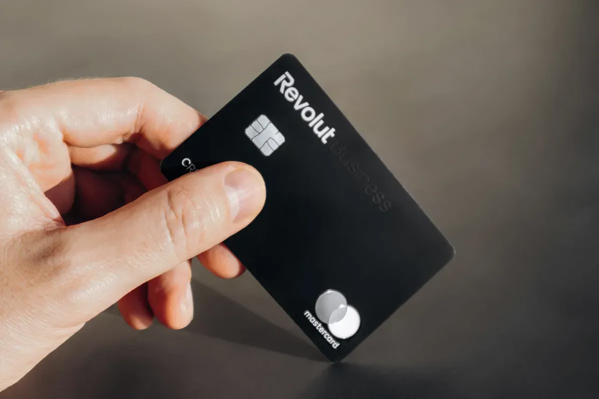 Dłoń trzyma czarną kartę Revolut Business. To banki, które nie współpracują z komornikiem, oferując bezpieczeństwo finansowe.