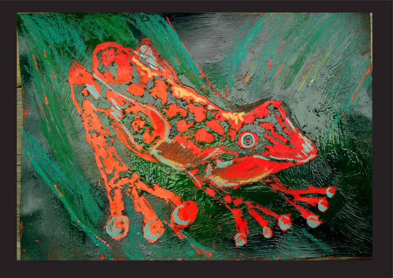 Żywy, czerwony płaz na tle zieleni. Intensywny zespół barw w obrazie podkreśla jego kształt i teksturę.