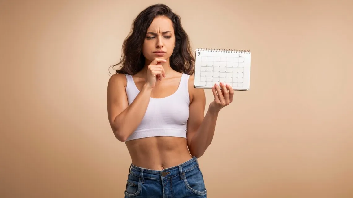 kobieta zastanawia się nad kalendarzem miesiączkowym