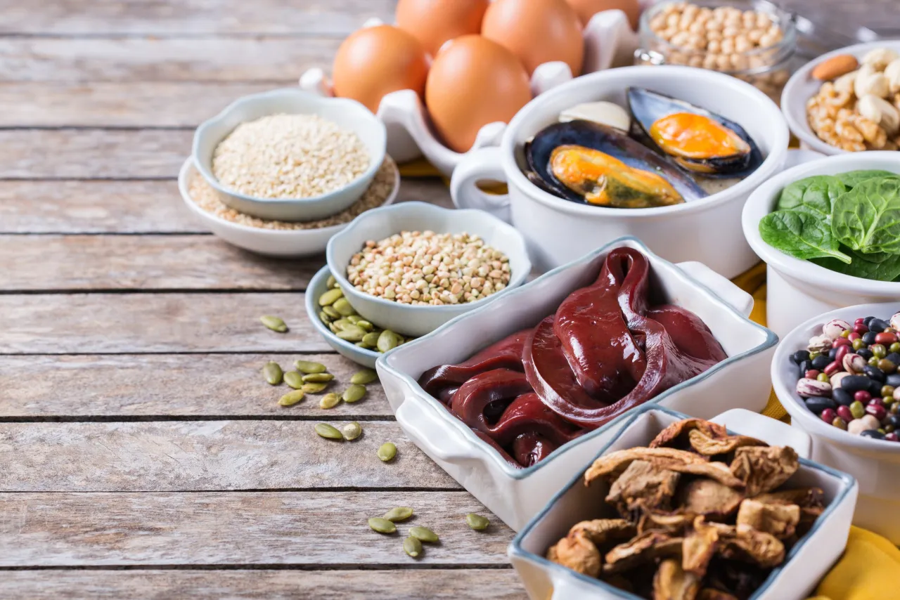 Talerz z jedzeniem bogatym w żelazo (szpinak, czerwone mięso, rośliny strączkowe)