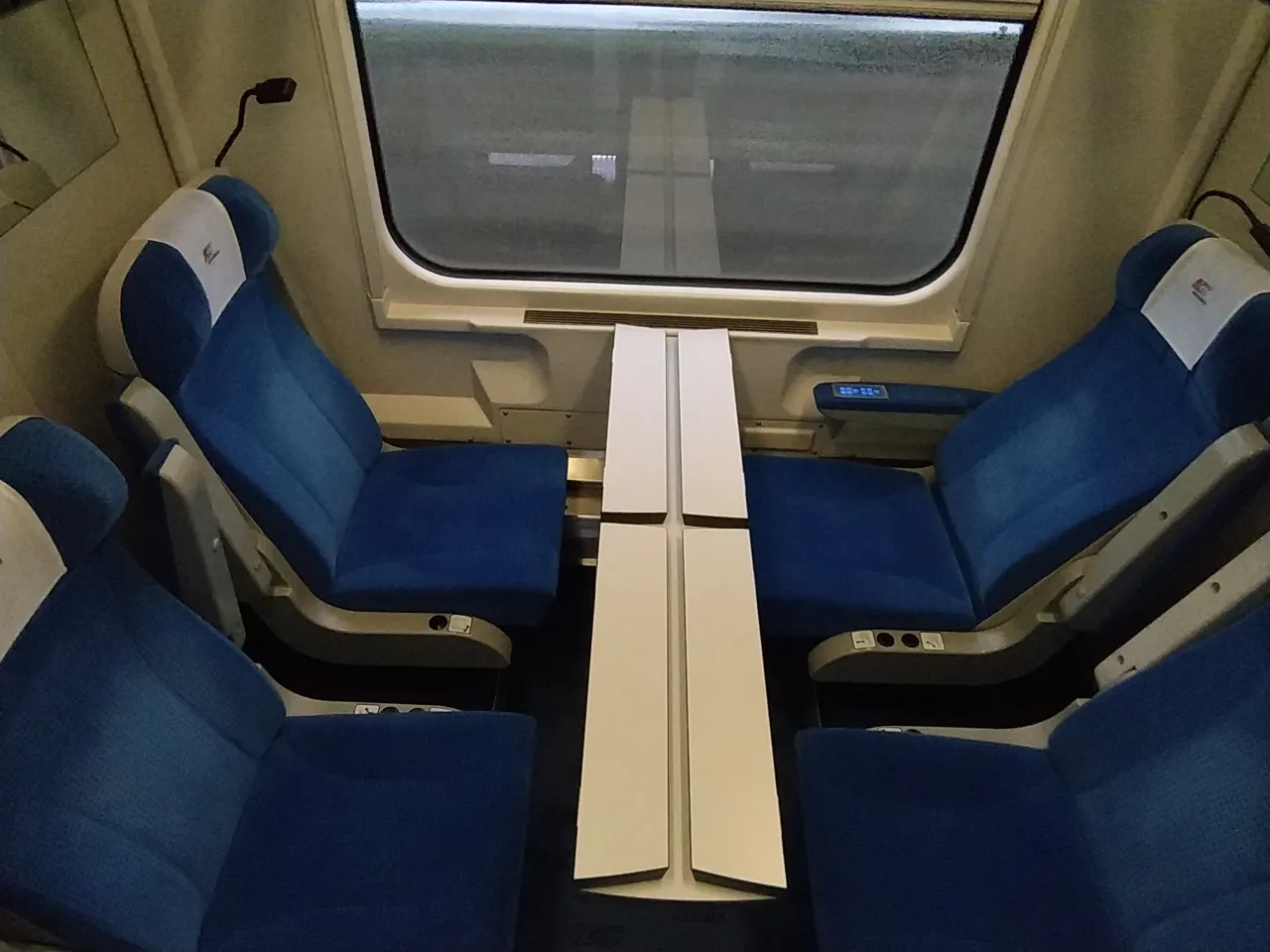 Komfortowe fotele i stolik w przedziale. Takie udogodnienia daje 1 klasa w Intercity, zapewniając wygodną podr&oacute;ż.