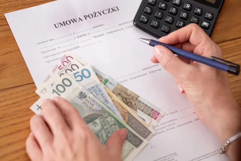 Umowa pożyczki prywatnej, długopis i kalkulator na stole