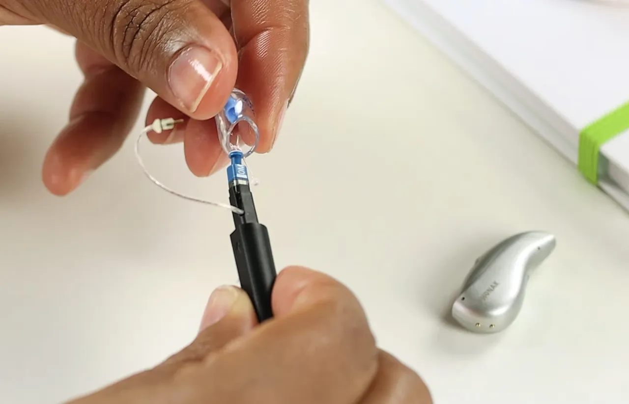 Dłonie wymieniają filtr w aparacie słuchowym. Dowiedz się, jak często wymienić filtr w aparacie słuchowym, aby zapewnić jego prawidłowe działanie.