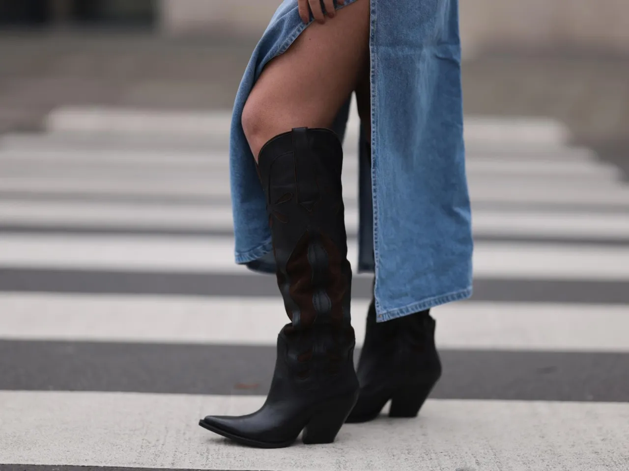 Frau kombiniert Cowboystiefel elegant mit Blazer und Jeans