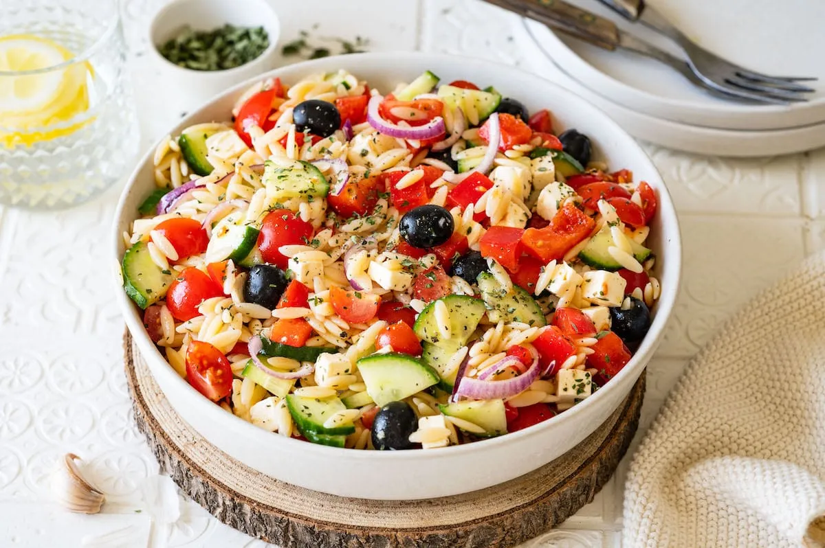 Griechischer Kritharaki Nudelsalat in einer Sch&uuml;ssel mit Feta und Oliven