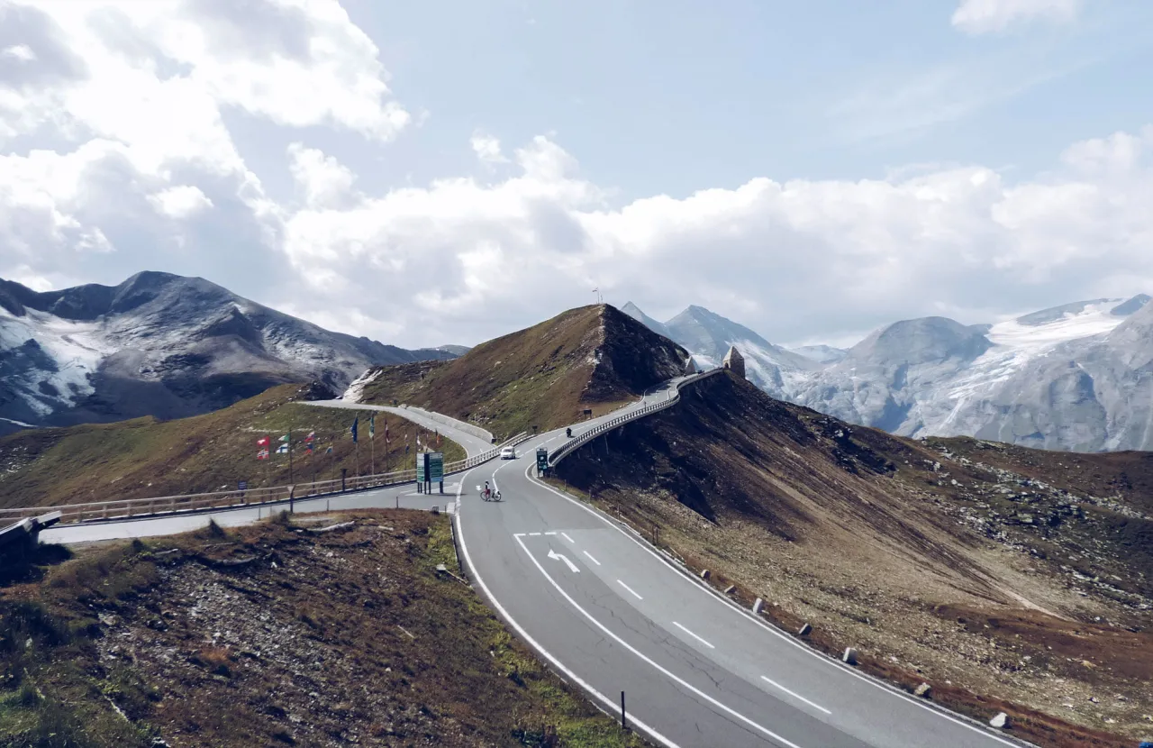 Motocyklista na alpejskiej przełęczy, zmienna pogoda