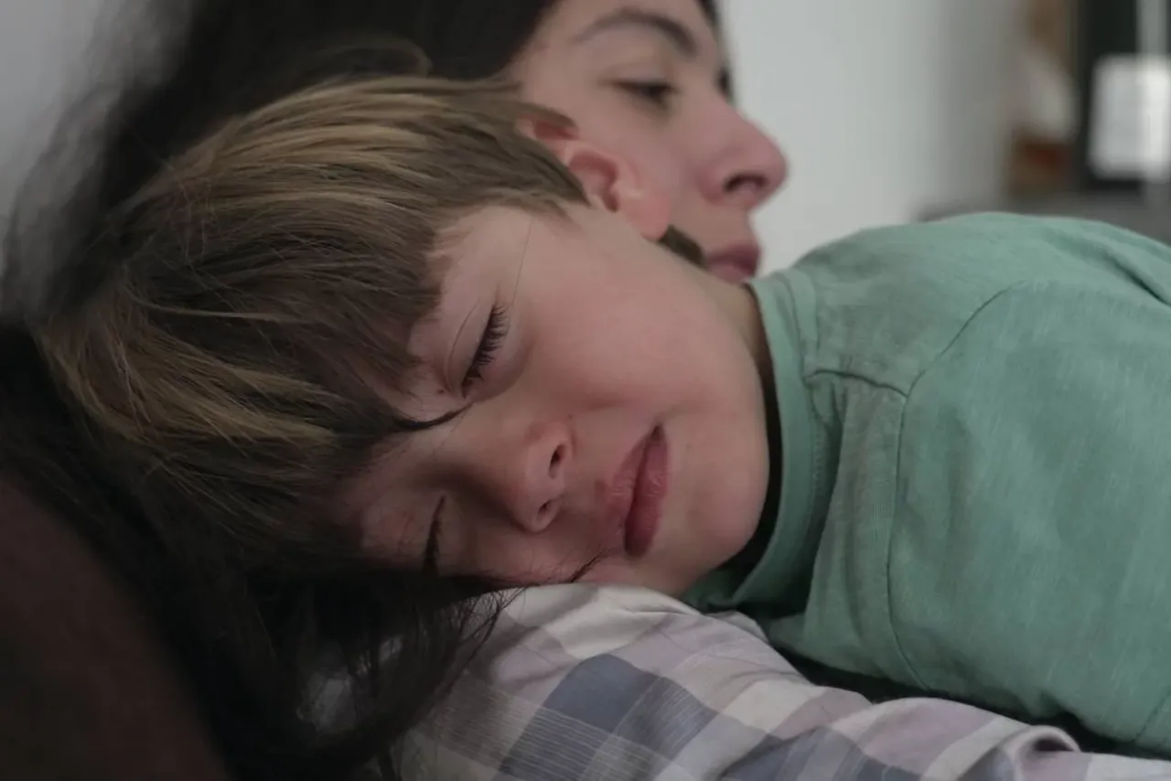 Rodzic zmęczony, ale przytulający płaczące dziecko