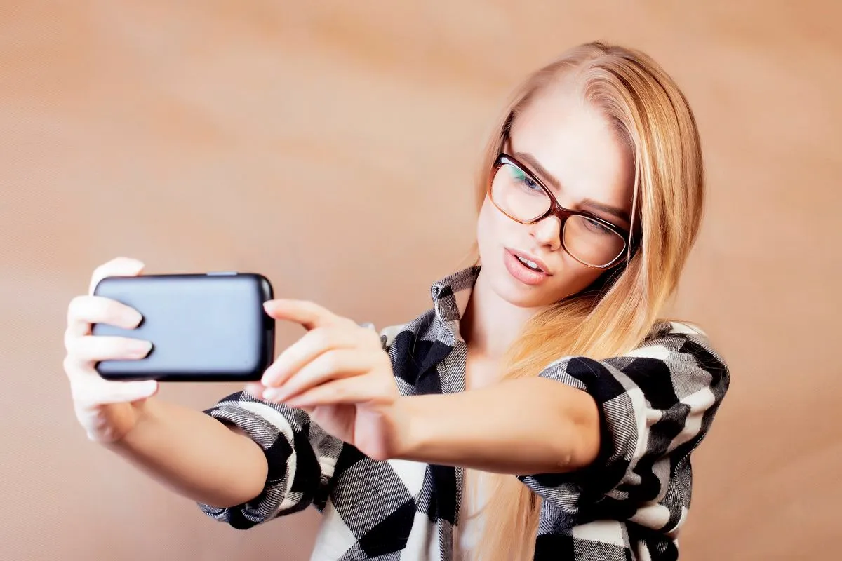 Młoda osoba z telefonem robiąca quiz psychologiczny