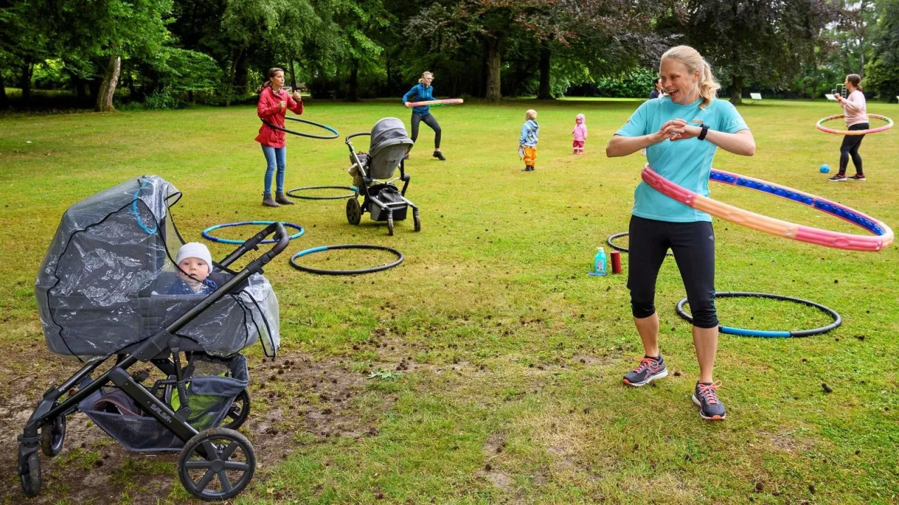 Kleinkinder spielen im Park mit Kinderwagen NRW