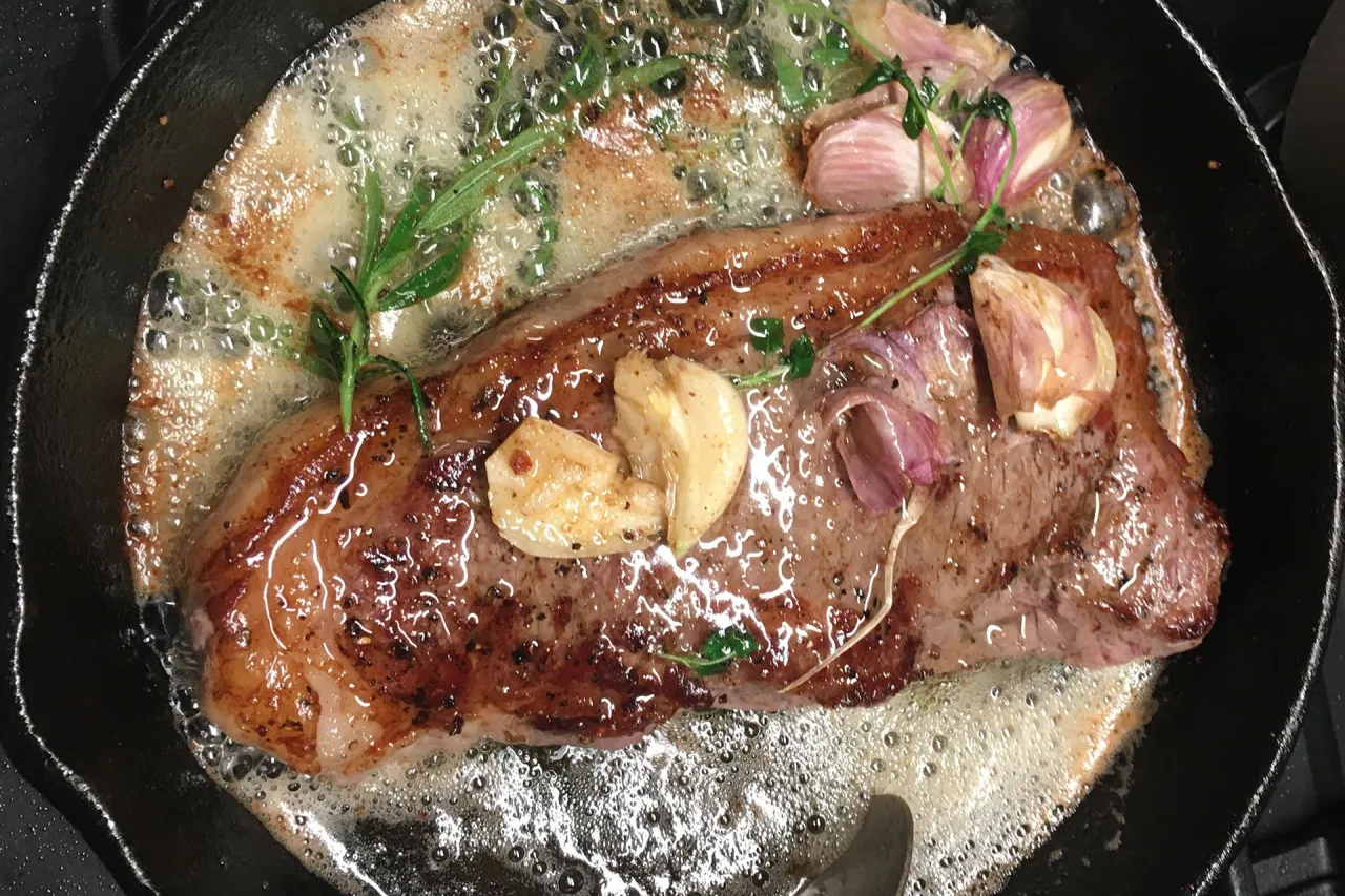 Soczysty stek smaży się na maśle z czosnkiem i ziołami, tworząc idealne sosy do steka.