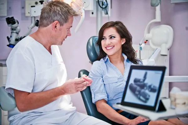 Pacjent rozmawiający z dentystą w gabinecie stomatologicznym