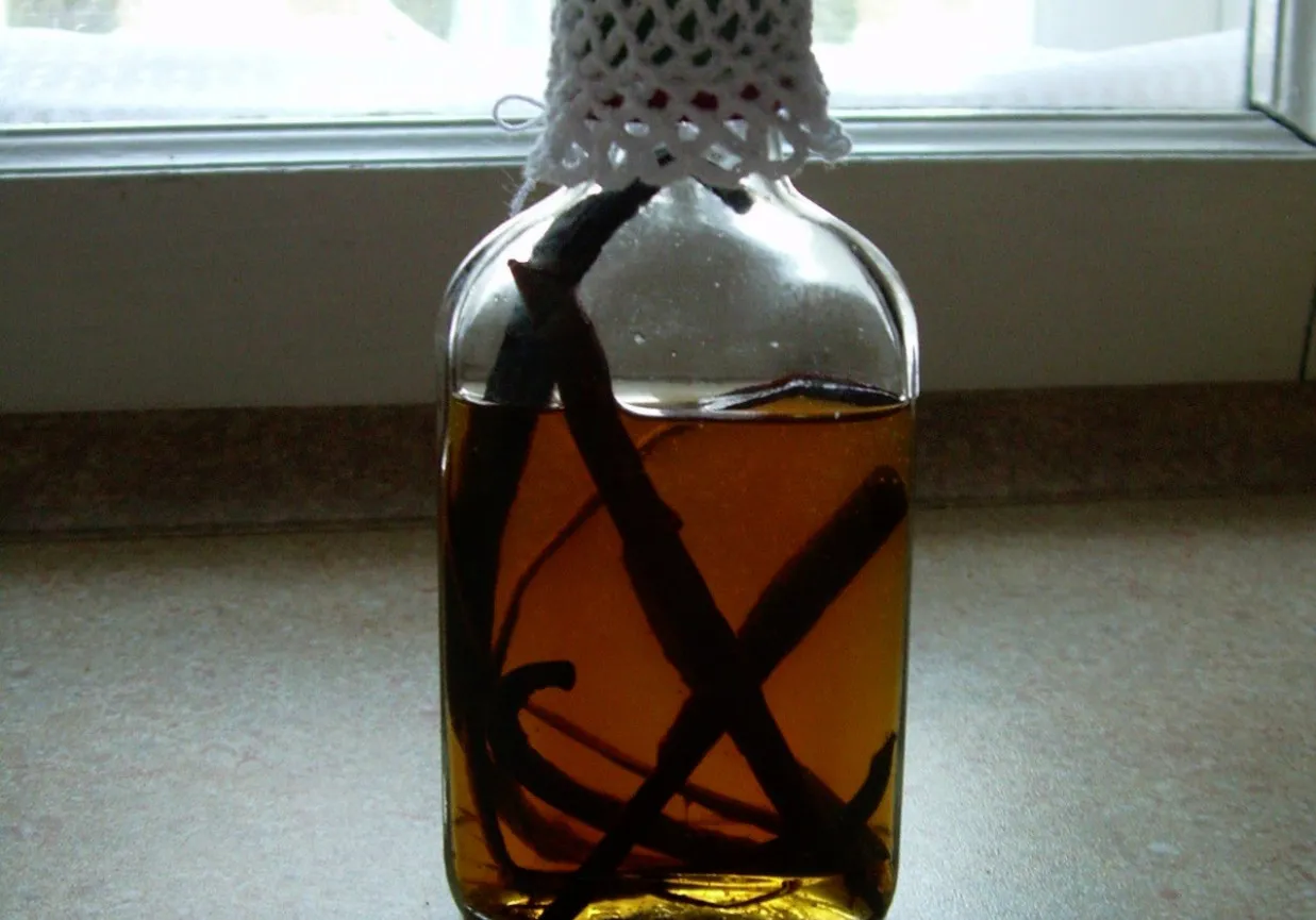 Składniki do ekstraktu waniliowego: laski wanilii i butelka w&oacute;dki