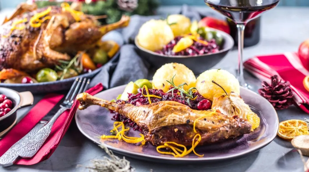 gęsina z winem, st&oacute;ł z gęsiną i kieliszkami wina