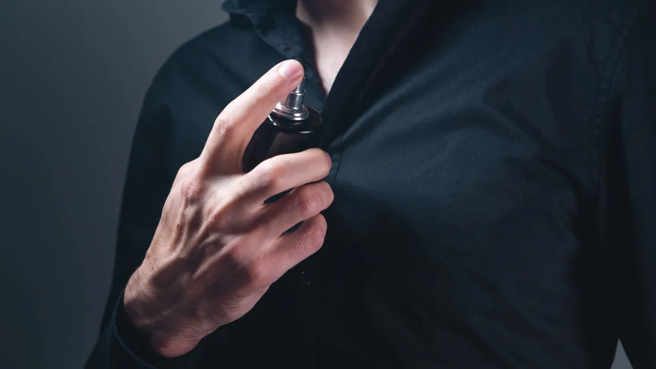 Elegante Person tr&auml;gt Parfum auf das Handgelenk auf