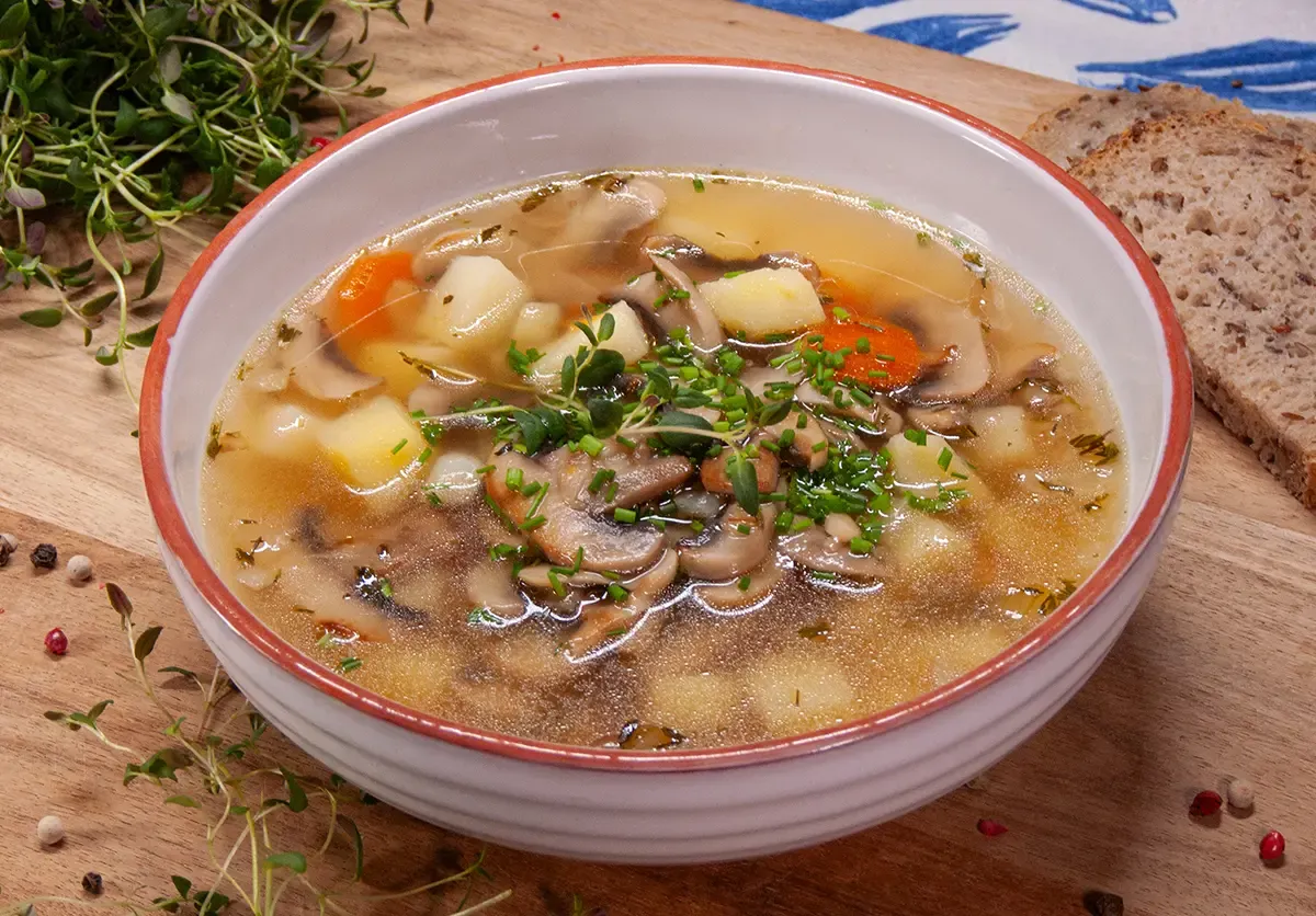 Świeże składniki na zupę pieczarkową: pieczarki, cebula, marchew, natka pietruszki