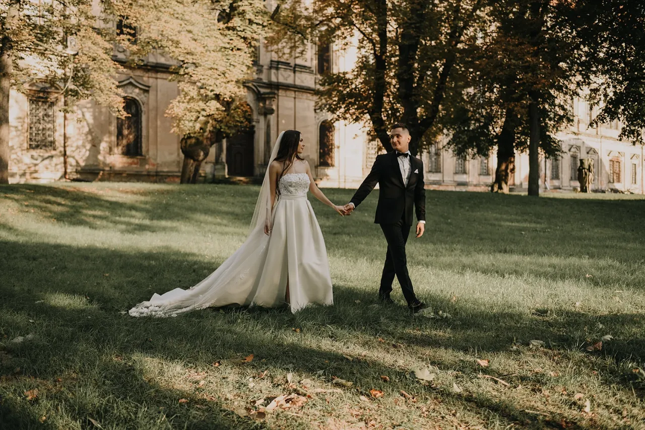 Para młoda przeglądająca album ze zdjęciami ślubnymi