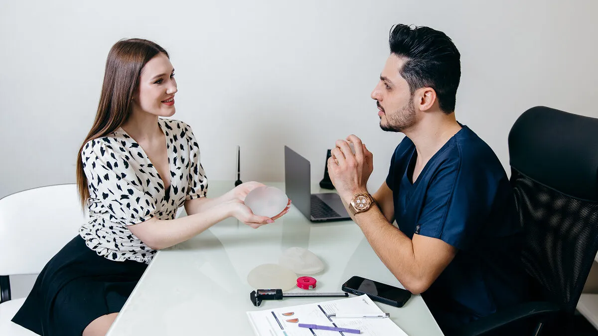 Kobieta rozmawiająca z chirurgiem plastycznym, konsultacja przed operacją biustu