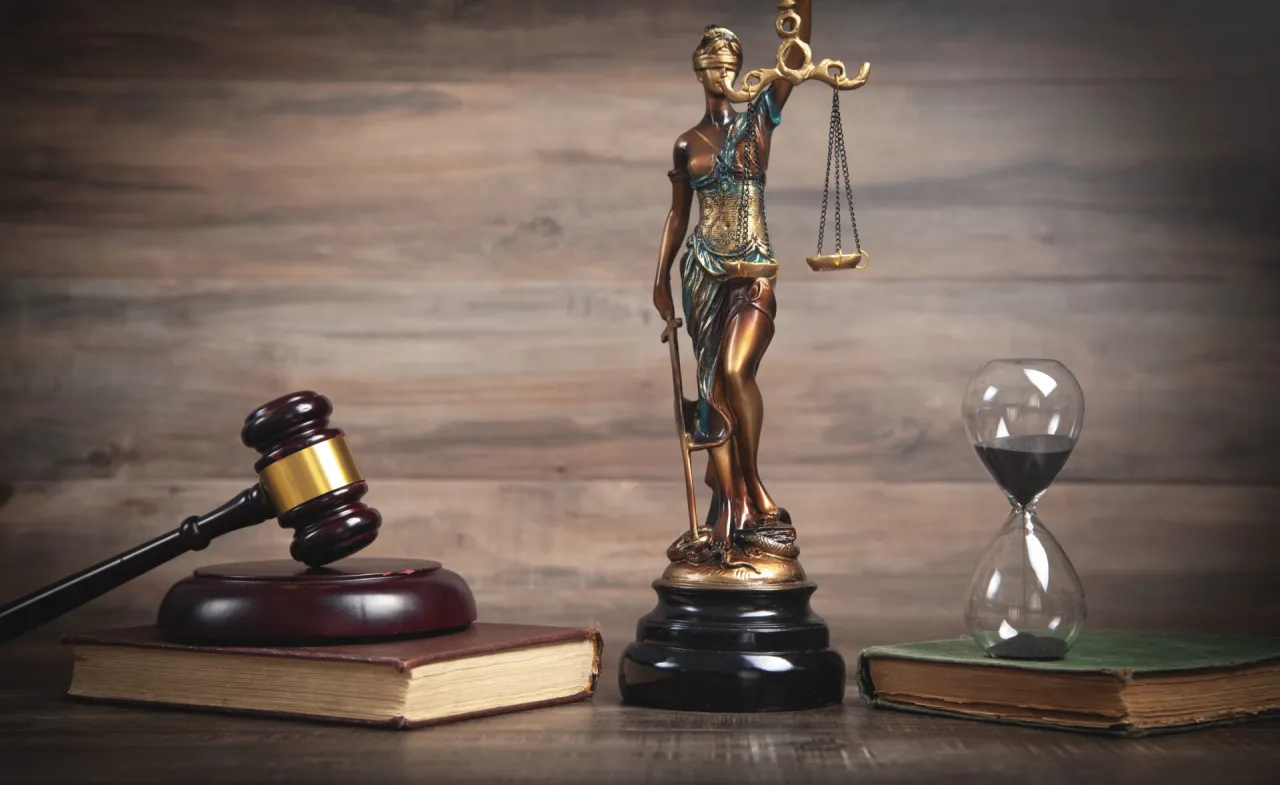 Sprawiedliwość i klepsydra symbolizują czas, który upływa, gdy zastanawiamy się, ile trwa apelacja w sprawie karnej.