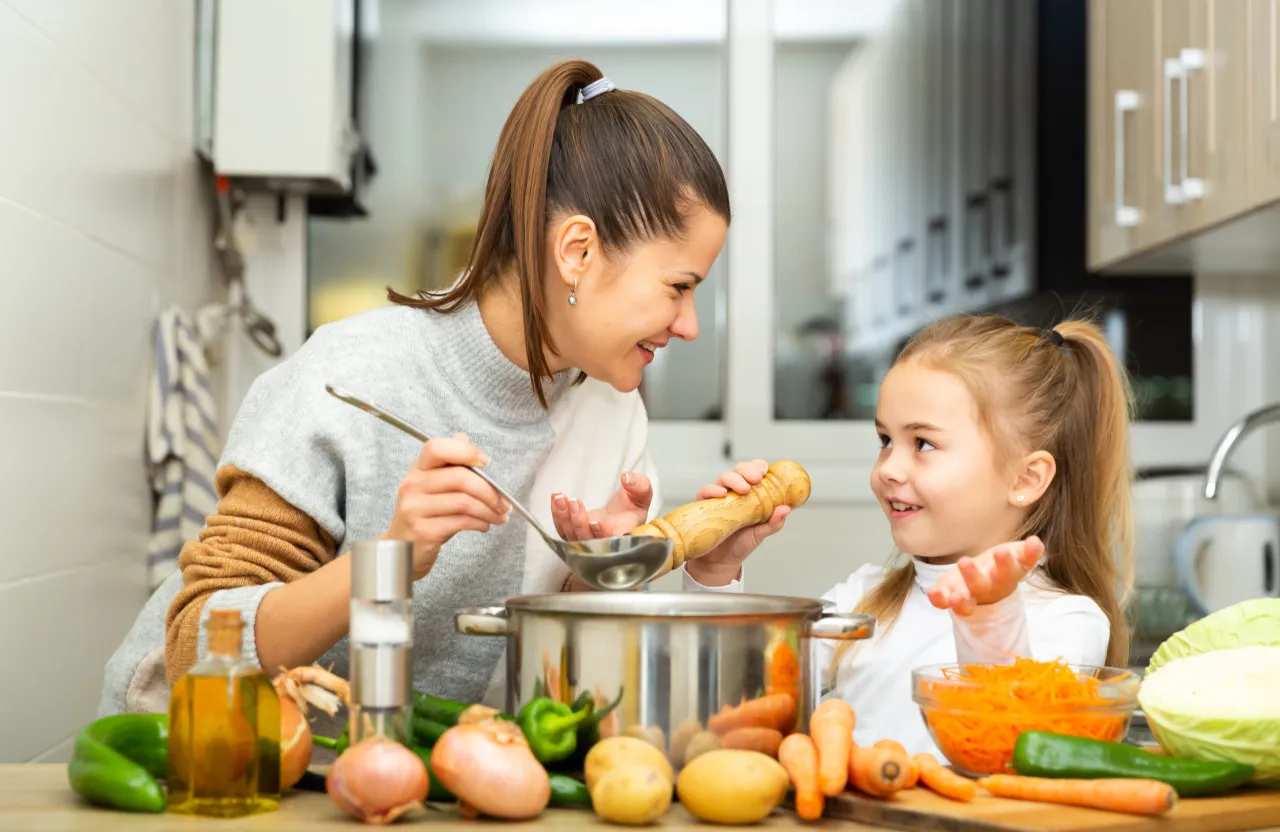 Dziecko jedzące zupkę z zi&oacute;łkami