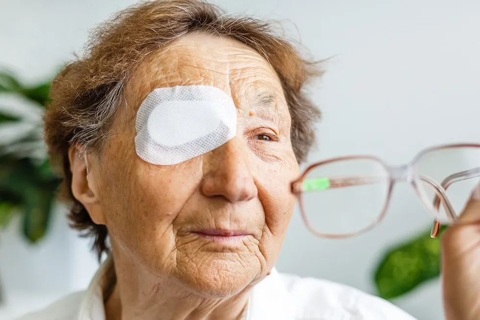 osoba z opatrunkiem na oku po operacji zaćmy