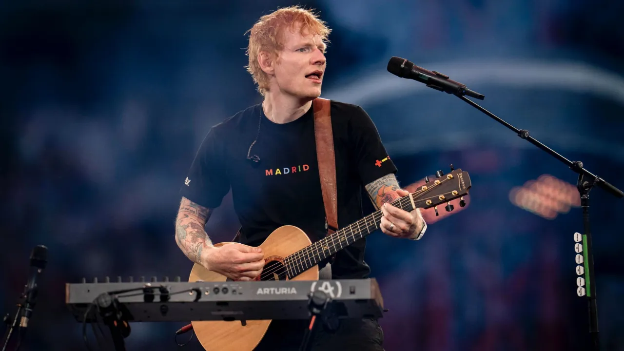 Ed Sheeran gra na gitarze podczas koncertu w Madrycie. Jego zarobki są imponujące, a fani zastanawiają się, ile zarabia Ed Sheeran.