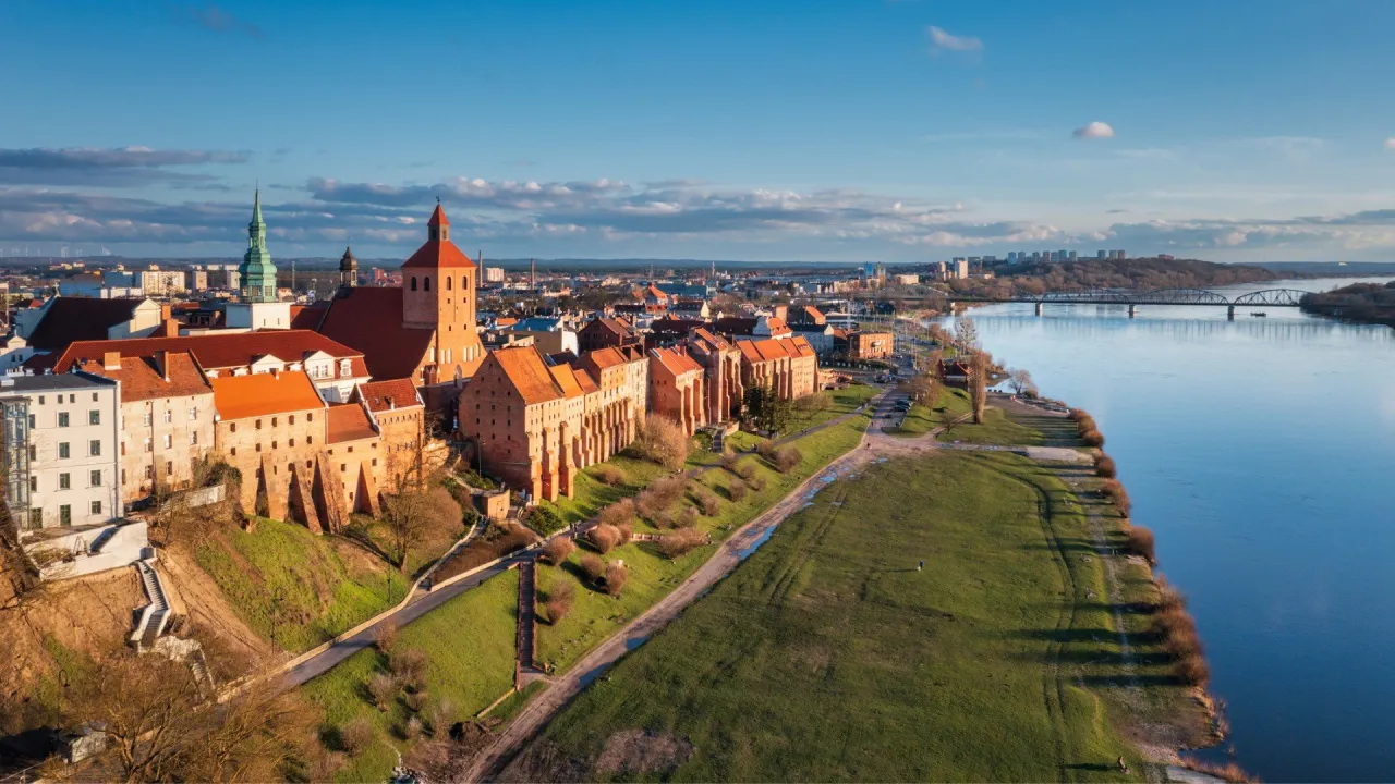 Toruń, jedno z najpiękniejszych miejsc w Polsce, z zamkiem krzyżackim i Wisłą w słoneczny dzień.