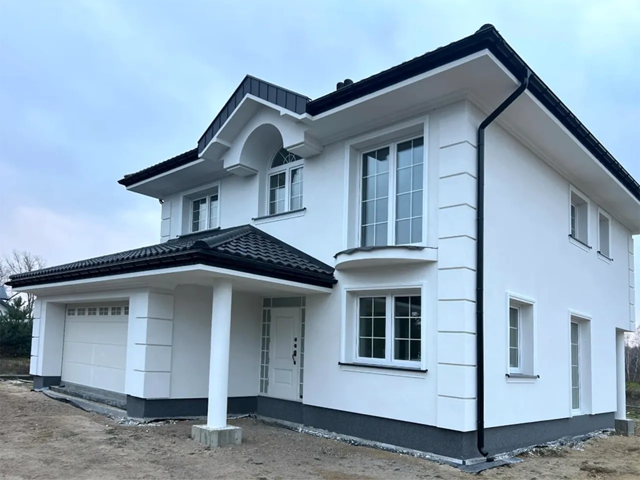 Nowoczesny dom z grafitowym dachem i jasną elewacją