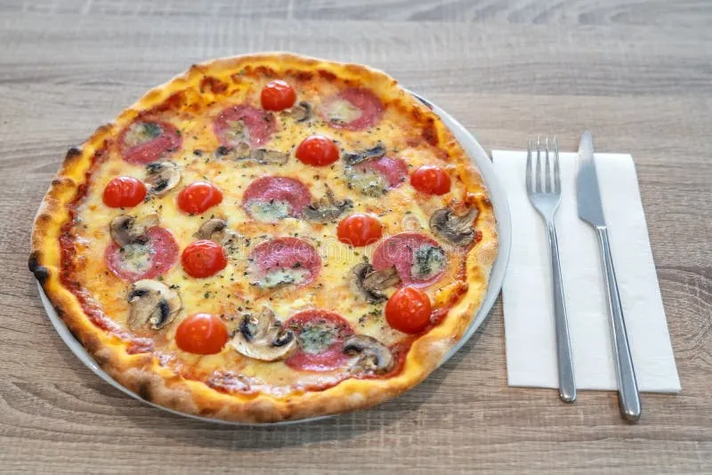 Włoska pizza na talerzu z nożem i widelcem